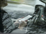 A motorist is stopped by police for talking on a cellphone while driving Wednesday in Vancouver.