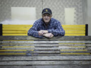 Sitting on a refurbished bench made with Alaska yellow cedar, volunteer Jim Bunzey leans forward on a weathered oak bench that he will restore in the workshop in the West Barracks&#039; old Post Hospital.