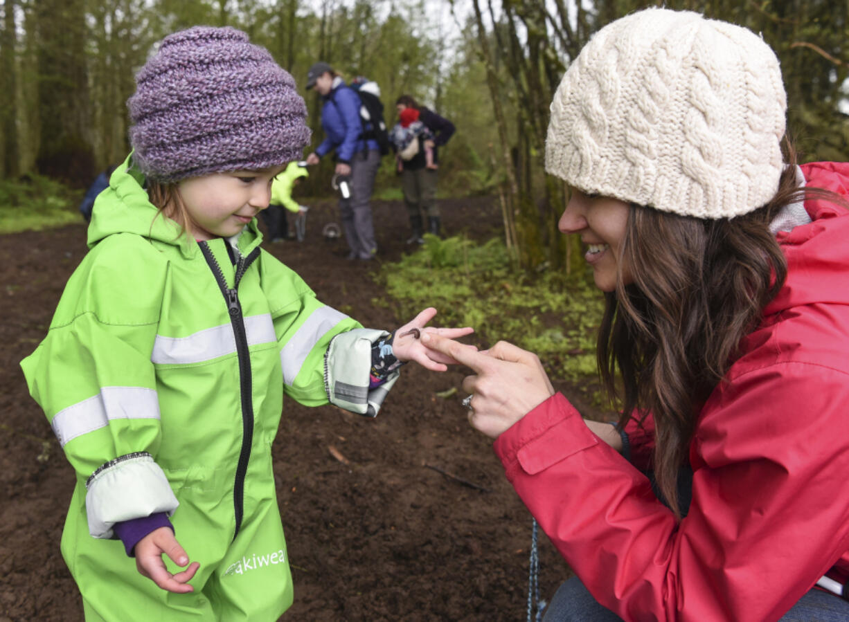 Eastyn Williams, 2, left, shows a worm she found to her mom, Debbie Williams, during Tinkergarten class at Hockinson Meadows Community Park on Thursday. The new program gives children ages 18 months through 5 years a chance to learn about nature through play.