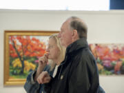 North Bank Artists founding members Rebecca Seymour, left, and Greg Lueck visit the current &quot;What Makes Us Happy&quot; exhibit. North Bank, which has always emphasized community and creativity over sales, will close at the end of May.