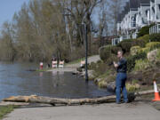 Ridgefield resident Jim Haden pauses to take photos along the flooded section of the Waterfront Renaissance Trail near Columbia Shores Condominiums. The National Weather Service first put the river under a flood watch on March 16.