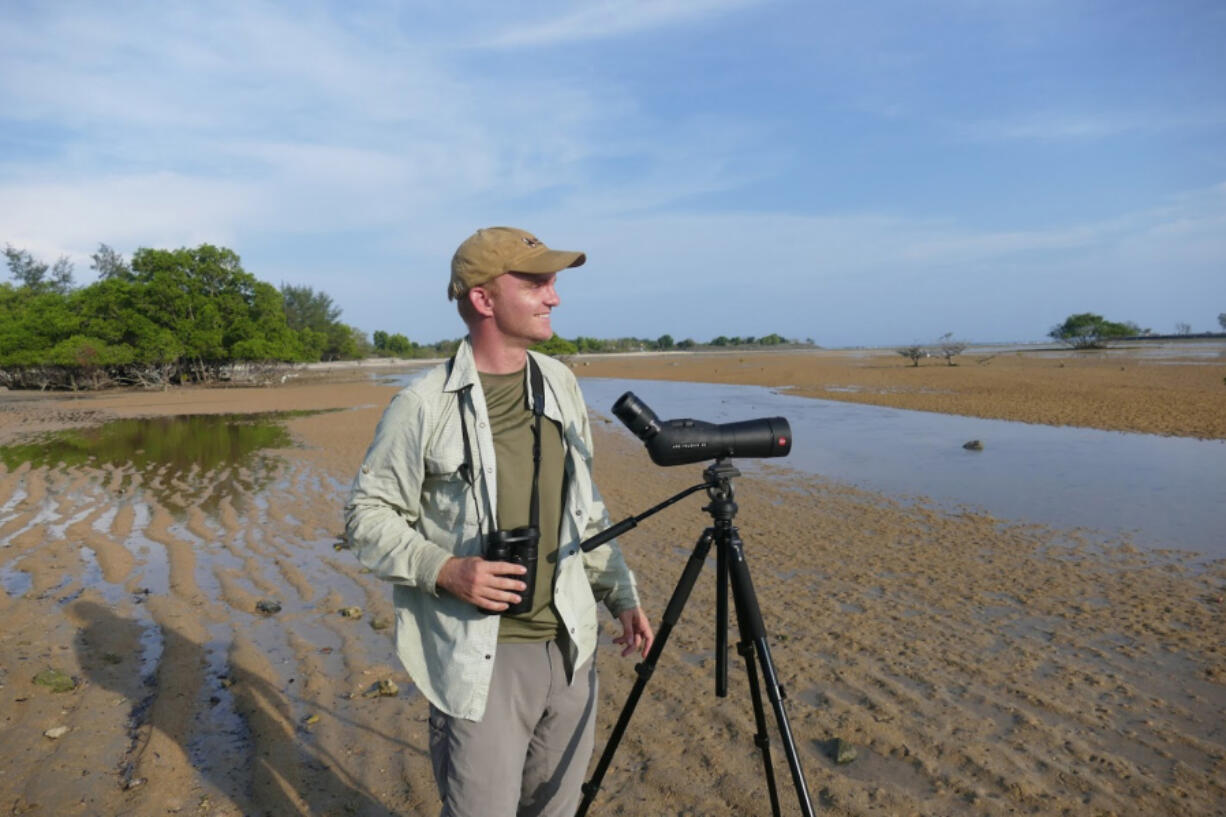 Noah Strycker scans for shorebirds near Denpasar, Bali, in 2015. That year Strycker set a world record for seeing the most birds in a single year. He spoke at an event held by the Vancouver Audubon Society.