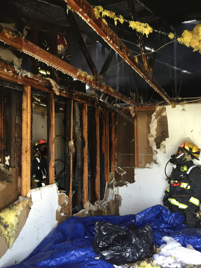 Firefighters deal with a fire that crept into a triplex&#039;s attic in east Vancouver, 903 S.E. 152nd Ave., Monday afternoon.