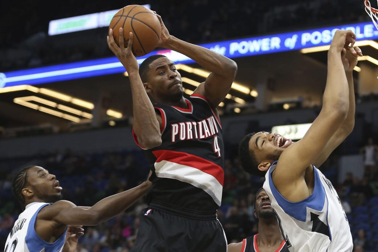 Portland Trail Blazers forward Maurice Harkless (4) grabs a rebound ball away from Minnesota Timberwolves center Karl-Anthony Towns, right, in the first half of an NBA basketball game, Monday, April 3, 2017, in Minneapolis.