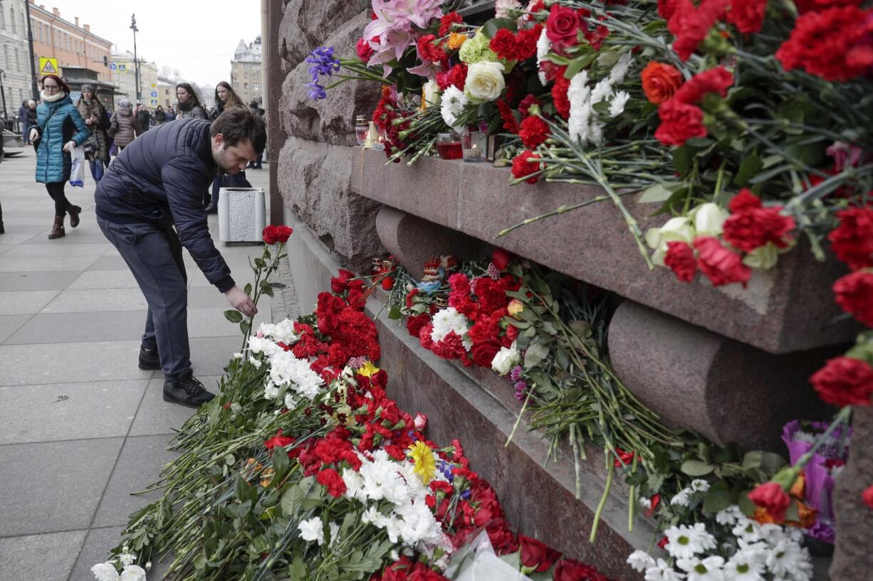 A man lays flowers at a symbolic memorial outside the Tekhnologichesky Institute subway station in St. Petersburg, Russia, Tuesday, April 4, 2017. A bomb blast tore through a subway train deep under Russia's second-largest city St. Petersburg Monday, killing several people and wounding many more in a chaotic scene that left victims sprawled on a smoky platform.