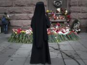 An Orthodox priest stands at a symbolic floral memorial at Technologicheskiy Institute subway station in St. Petersburg, Russia, Tuesday, April 4, 2017. A bomb blast tore through a subway train deep under Russia's second-largest city St. Petersburg Monday, killing several people and wounding many more in a chaotic scene that left victims sprawled on a smoky platform.