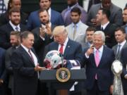 New England Patriots head coach Bill Belichick presents President Donald Trump with a Patriots helmet during a ceremony on the South Lawn of the White House in Washington, Wednesday, April 19, 2017, where the president honored the Super Bowl Champion New England Patriots for their Super Bowl LI victory. Patriots owner Robert Kraft is at right.