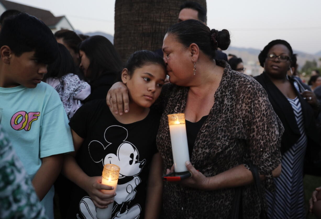 Betty Rodriguez, right, comforts her granddaughter Giselle during a prayer service held to honor the shooting victims at North Park Elementary School on Monday in San Bernardino, Calif. A man walked into his estranged wife&#039;s elementary school classroom in San Bernardino and opened fire on Monday. (AP Photo/Jae C.