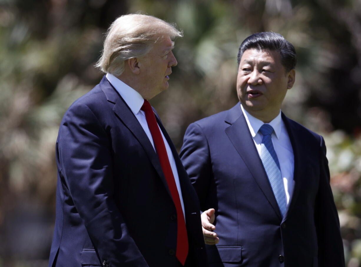 President Donald Trump, left, and Chinese President Xi Jinping walk together after their meetings at Mar-a-Lago, in Palm Beach, Fla.