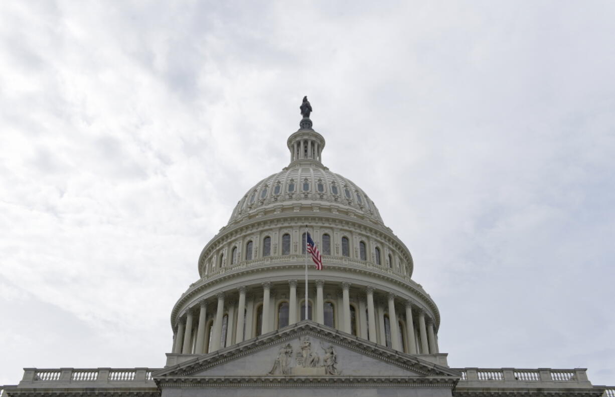 In this photo taken Feb. 28, 2017, a flag flies on Capitol Hill in Washington. Lawmakers return to Washington this week to a familiar quagmire on health care legislation and a budget deadline dramatized by the prospect of a protracted battle between President Donald Trump and congressional Democrats over his border wall.