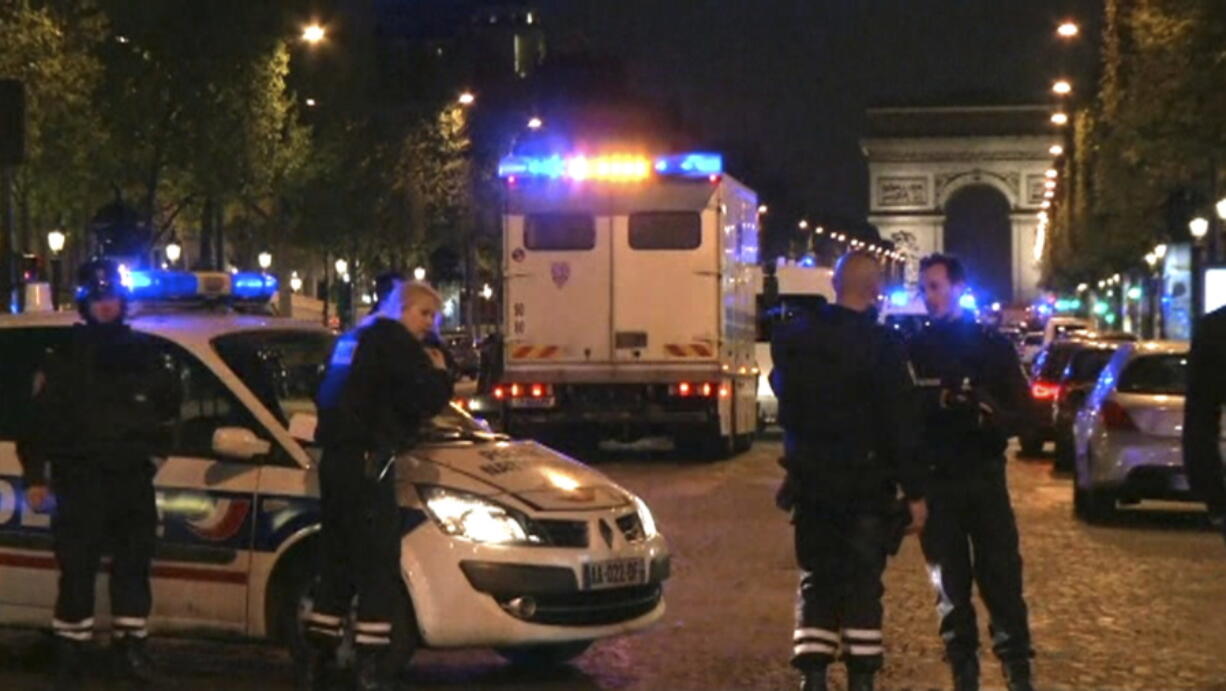 In this image made from video, police attend the scene after an incident on the Champs-Elysees with Arc de Triomphe in background in Paris, Thursday April 20, 2017.  French media are reporting that two police officers were shot Thursday on the famed shopping boulevard.