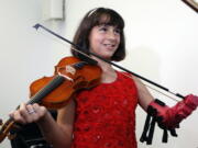 Isabella Nicola Cabrera, 10, plays her violin with her new prosthetic Thursday at the engineering department of George Mason University in Fairfax, Va. &quot;Oh my gosh, that&#039;s so much better,&quot; Isabella said as she tried it out.