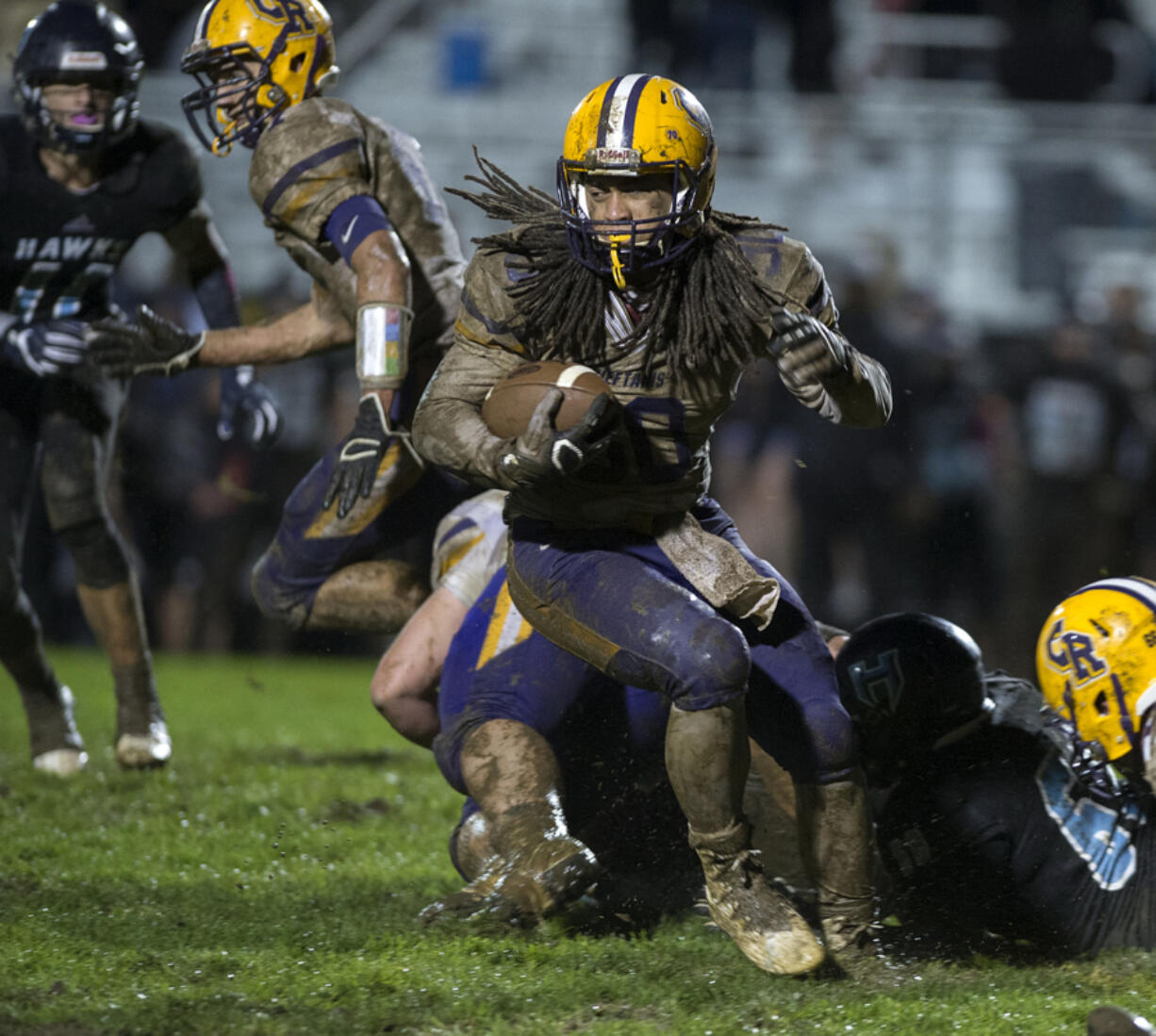 Columbia River's Hunter Pearson, with ball, makes his way through a muddy Hockinson High School field in October. Hockinson School District officials are asking residents why they voted against a capital project levy in February to replace the field with synthetic turf, as the current field doesn't drain too well given the region's heavy rain.