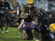 Columbia River's Hunter Pearson, with ball, makes his way through a muddy Hockinson High School field in October. Hockinson School District officials are asking residents why they voted against a capital project levy in February to replace the field with synthetic turf, as the current field doesn't drain too well given the region's heavy rain.