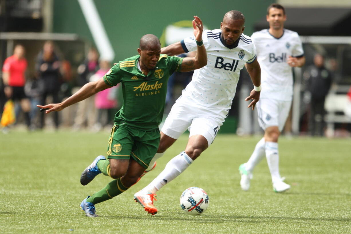 Portland Timbers&#039; Darlington Nagbe, left, fights to get free before scoring in the first half against the Whitcaps.