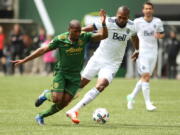 Portland Timbers&#039; Darlington Nagbe, left, fights to get free before scoring in the first half against the Whitcaps.