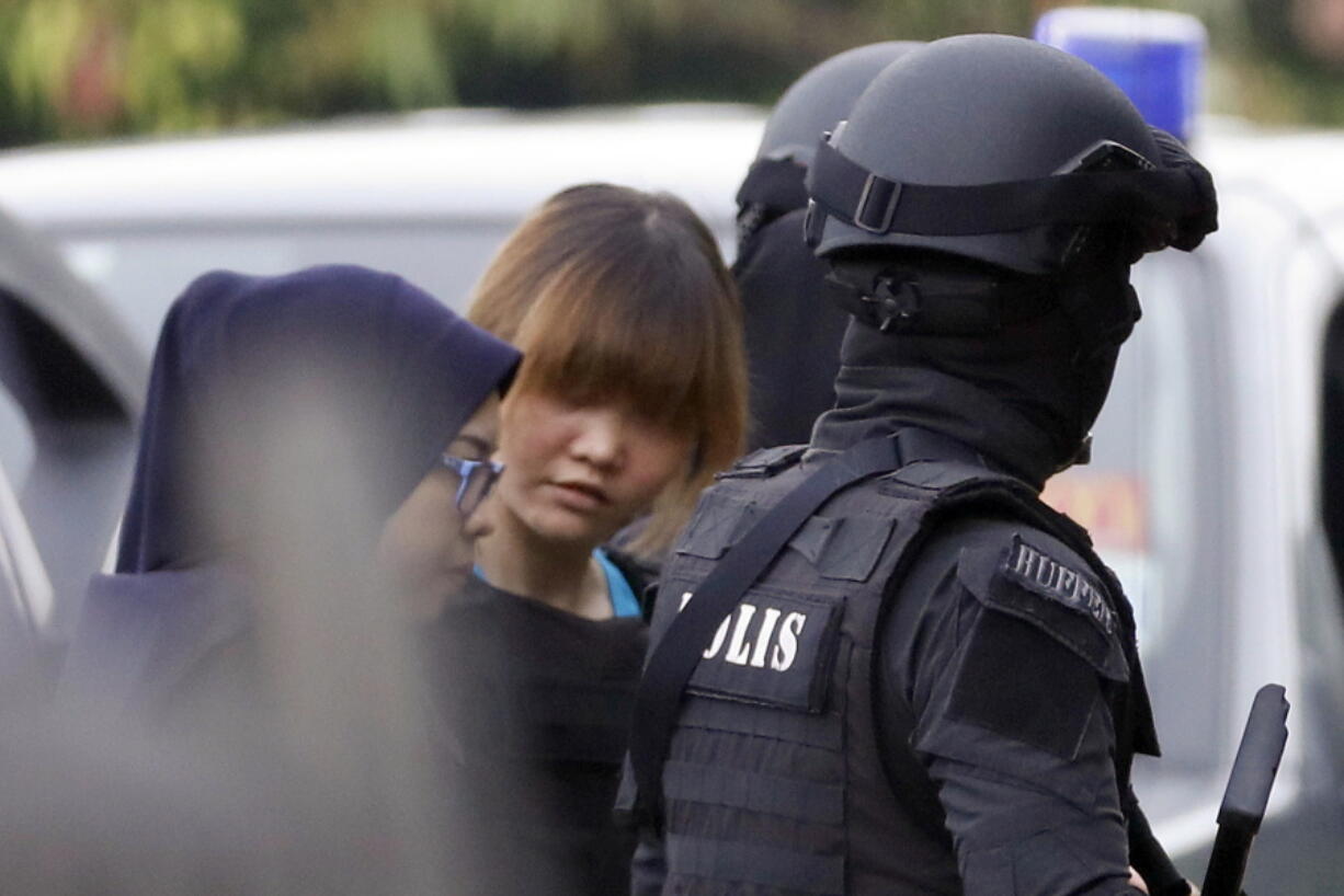 Doan Thi Huong, center, one of the suspects in the death of Kim Jong Nam, is escorted by police officers Thursday as she arrives at a courthouse in Sepang, Malaysia.