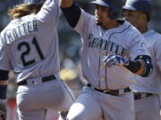 Nelson Cruz, right, celebrates with Taylor Motter (21) after hitting a three run home run in the seventh inning of Seattle&#039;s win in Oakland.