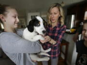 Morgan Fredette, 13, from left, holds Roscoe as her mother Kate and brother Lucas, 11, play.