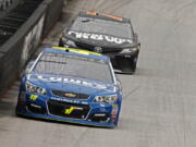 Driver Jimmie Johnson (48) leads driver Martin Truex Jr. (78) down the back stretch during a NASCAR Monster Energy NASCAR Cup Series auto race, Monday, April 24, 2017 in Bristol, Tenn.