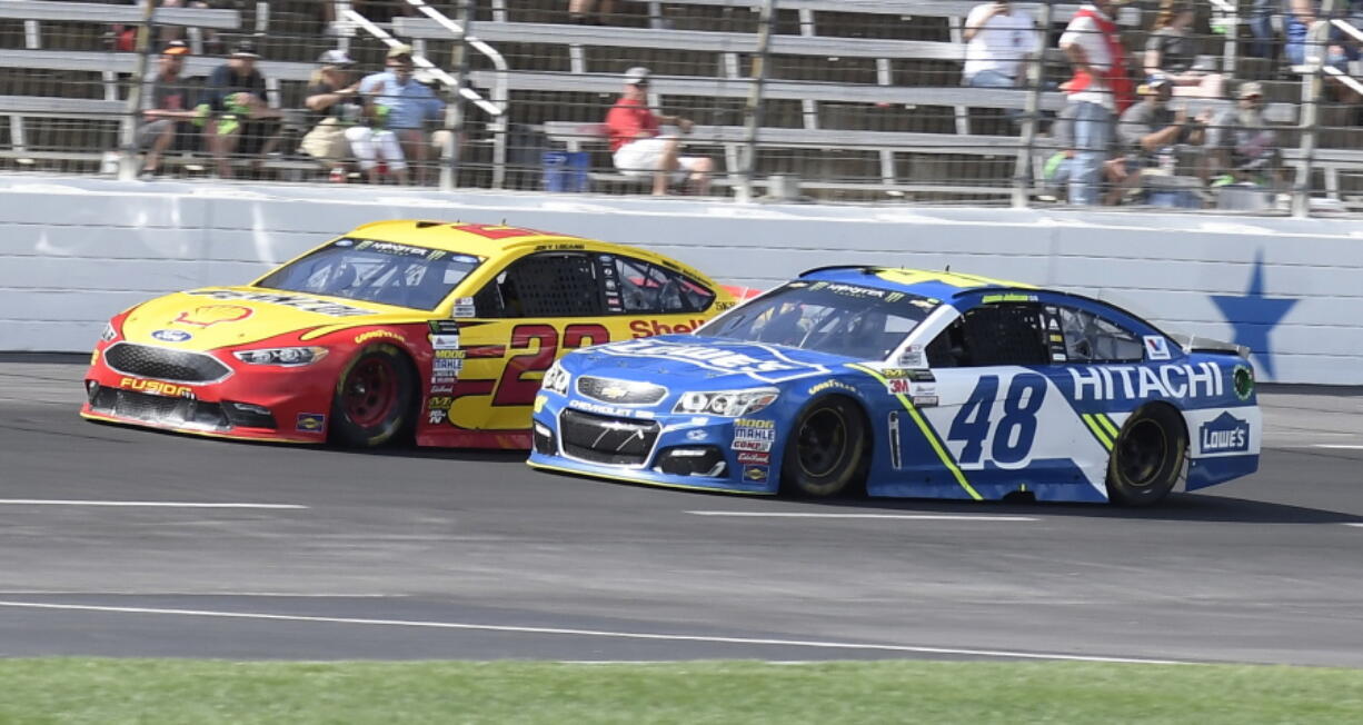 Jimmie Johnson (48) passes Joey Logano (22) on the front stretch with late in the NASCAR Cup Series auto race at Texas Motor Speedway in Fort Worth, Texas, Sunday, April 9, 2017. Johnson won the race.