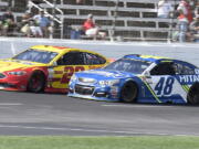 Jimmie Johnson (48) passes Joey Logano (22) on the front stretch with late in the NASCAR Cup Series auto race at Texas Motor Speedway in Fort Worth, Texas, Sunday, April 9, 2017. Johnson won the race.