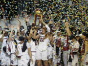 South Carolina forward A&#039;ja Wilson (22) holds the trophy as she and teammates celebrate their win over Mississippi State in the final of NCAA women&#039;s Final Four college basketball tournament, Sunday, April 2, 2017, in Dallas.