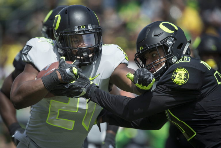 Team Free's Royce Freeman battles for yardage with Team Brave's Ty Griffin during during Oregon's spring NCAA college football game at Autzen Stadium in Eugene Ore., Saturday, April 29, 2017.