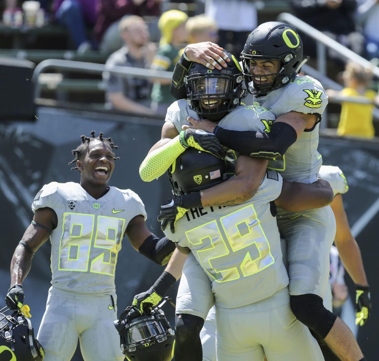 Oregon's Darren Carrington II, center right, is congratulated by teammates Kani Benoit (29) Darrian McNeal, top right, after Carrington's third touchdown during Oregon's spring NCAA college football game at Autzen Stadium in Eugene Ore., Saturday, April 29, 2017.