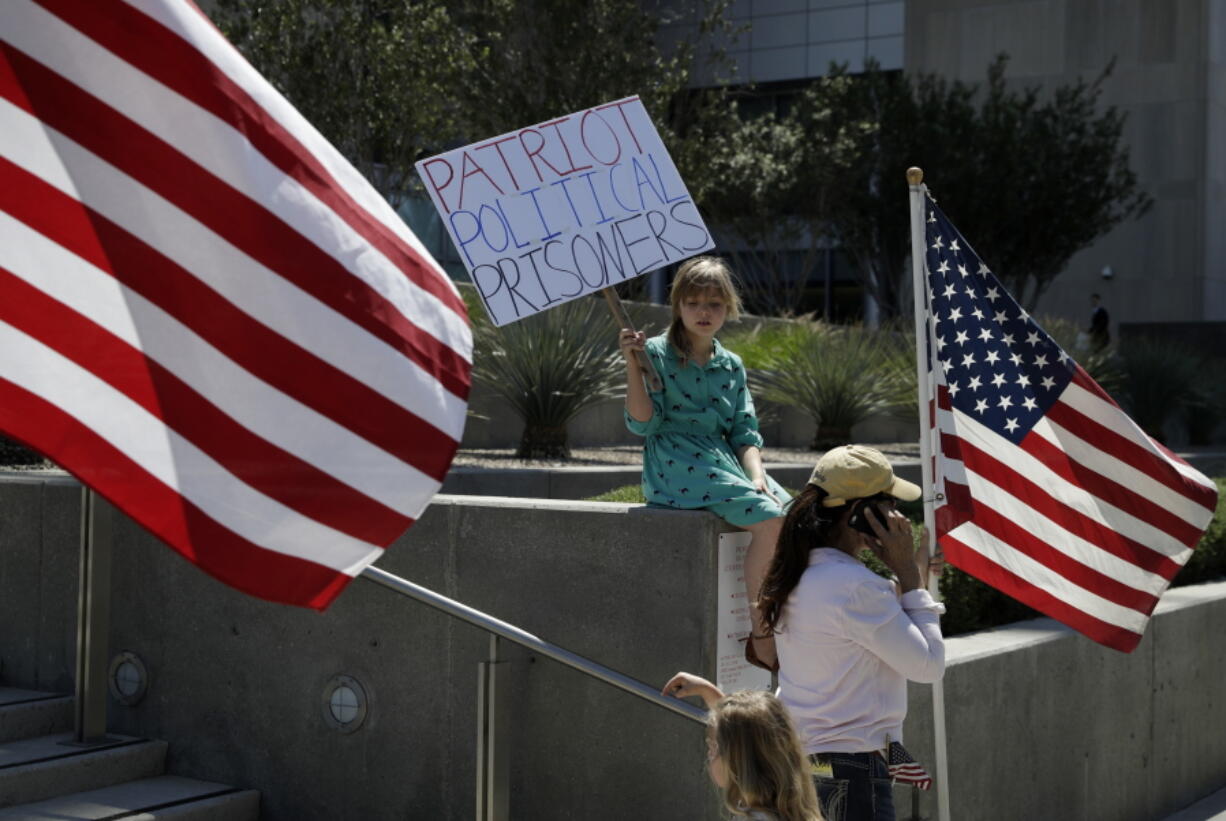 Nine-year-old Paylynn Lawrimore holds up a sign in support of defendants on trial in federal court on Wednesday in Las Vegas. A federal jury in Las Vegas heard closing arguments in the trial of six men accused of wielding weapons to stop federal agents from rounding up cattle near Nevada rancher Cliven Bundy&#039;s property in 2014.