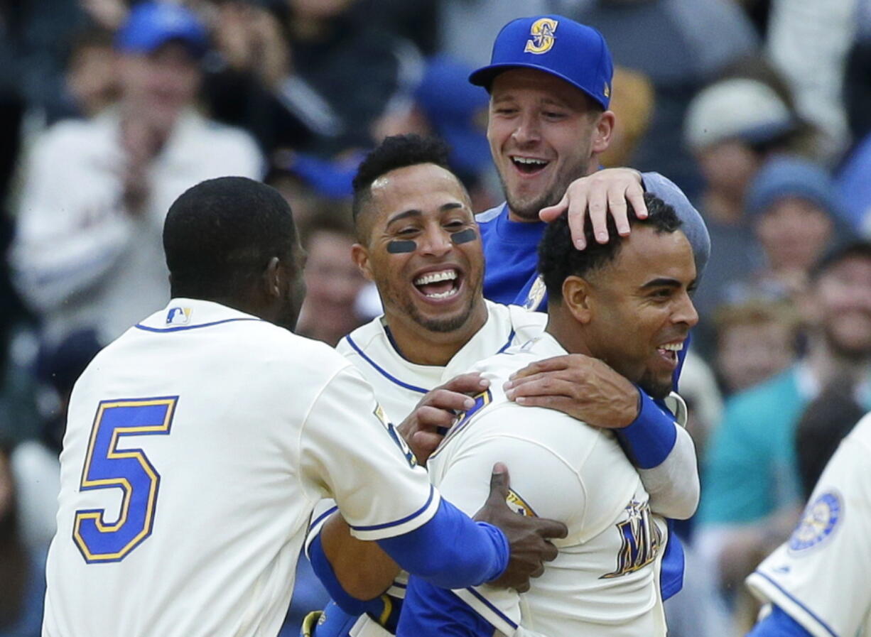 Seattle Mariners&#039; Nelson Cruz, right, is greeted by teammates including Leonys Martin, second from left, and Guillermo Heredia (5) after Cruz hit a walk-off single in the ninth inning to score Mariners&#039; Mike Freeman and give the Mariners a 8-7 win over the Texas Rangers, Sunday, April 16, 2017, in Seattle. (AP Photo/Ted S.