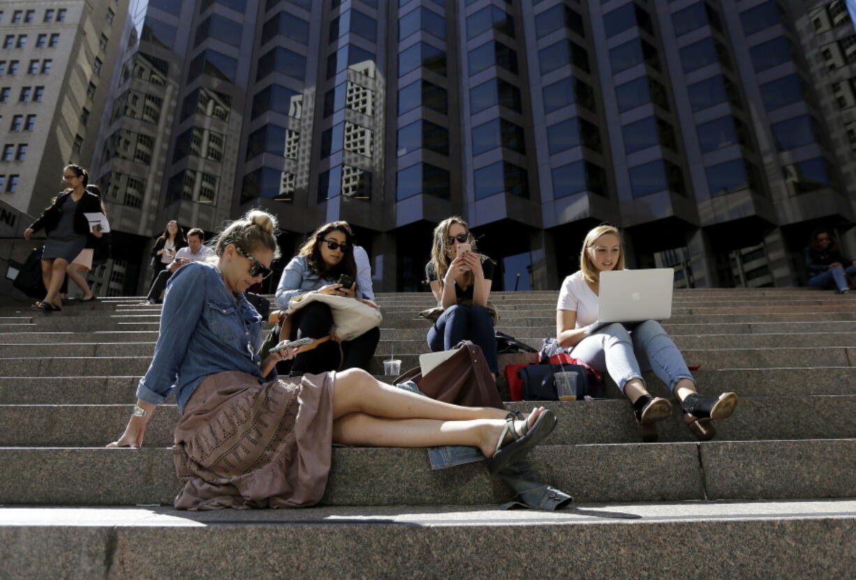 From left, Kate Davis, Alex Rodriguez, Molly Gasch and Marissa Osowsky work on the steps across from their office at BBDO San Francisco during a power outage Friday in San Francisco.