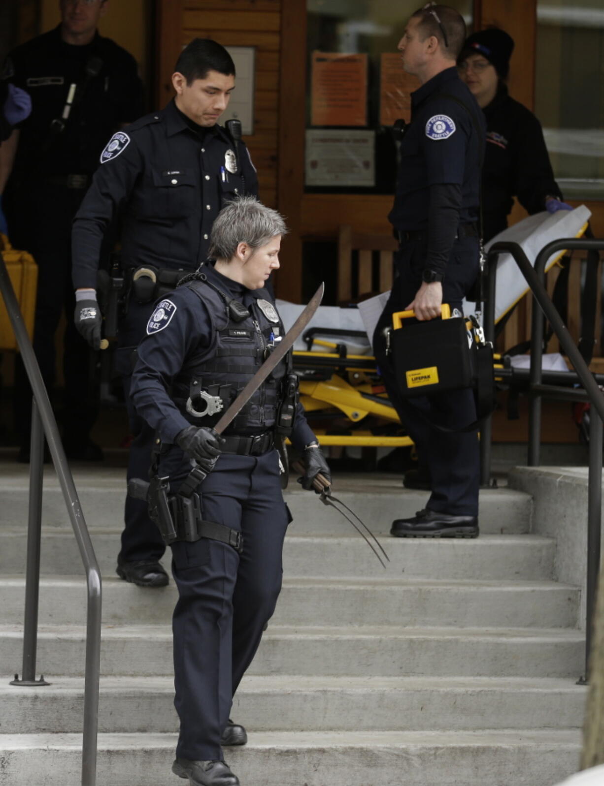 A Seattle Police officer carries knives out of an apartment building in Seattle after officers, including several members of SPD&#039;s crisis response unit, were able to peacefully take the owner of the knives into custody after he had barricaded himself inside his apartment on March 2, 2016. A new report from a court-appointed monitor released Thursday says that the use of serious levels of force by Seattle police is down 60 percent since the federal government imposed reforms on the department. (AP Photo/Ted S. Warren) (Photos by Ted S.