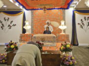 In this April 9, 2017 photo, a Sikh man bows as Satinder Kaur leads a prayer recital at the Guru Nanak Darbar house of worship, in Hicksville, N.Y. Women and men share equal roles in the temple where Sikhs come together for worship and to serve community meals free for anyone regardless of faith, religion or background.