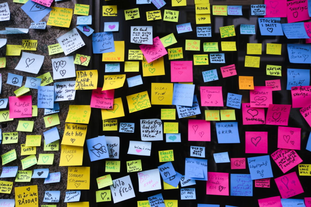 Messages are pinned to a window at the department store Ahlens in Stockholm, Sweden. A hijacked truck was driven into a crowd of pedestrians and crashed into a department store on Friday.