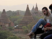 In this Monday, March 13, 2017 photo, tourists gather on Shwesandaw Pagoda to watch the sunset over thousands of pagodas in the ancient Myanmar city of Bagan.  The city is home to the largest concentration of Buddhist temples, stupas and monuments in the world, most of which were built in the 11th and 12th centuries.