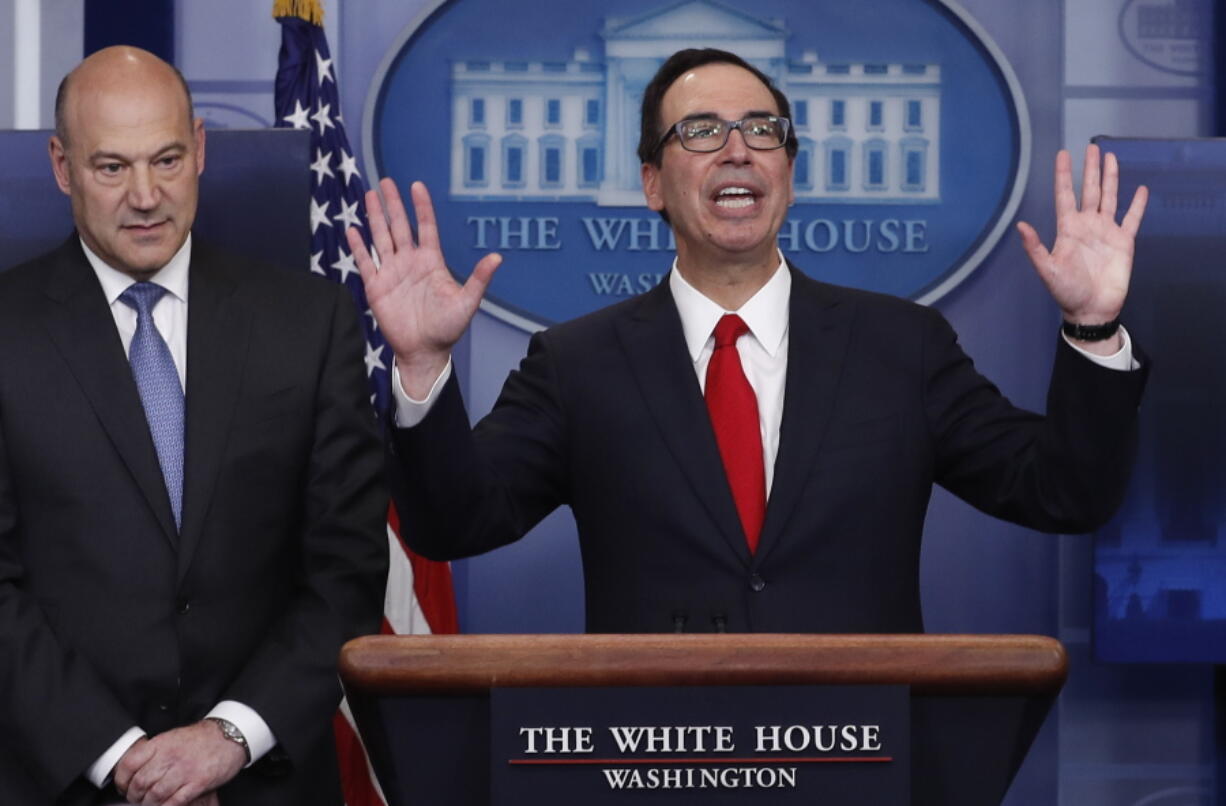 Treasury Secretary Steven Mnuchin, right, joined by National Economic Director Gary Cohn, speaks in the briefing room of the White House in Washington, Wednesday, April 26, 2017. President Donald Trump is proposing dramatically reducing the taxes paid by corporations big and small in an overhaul his administration says will spur economic growth and bring jobs and prosperity to the middle class.