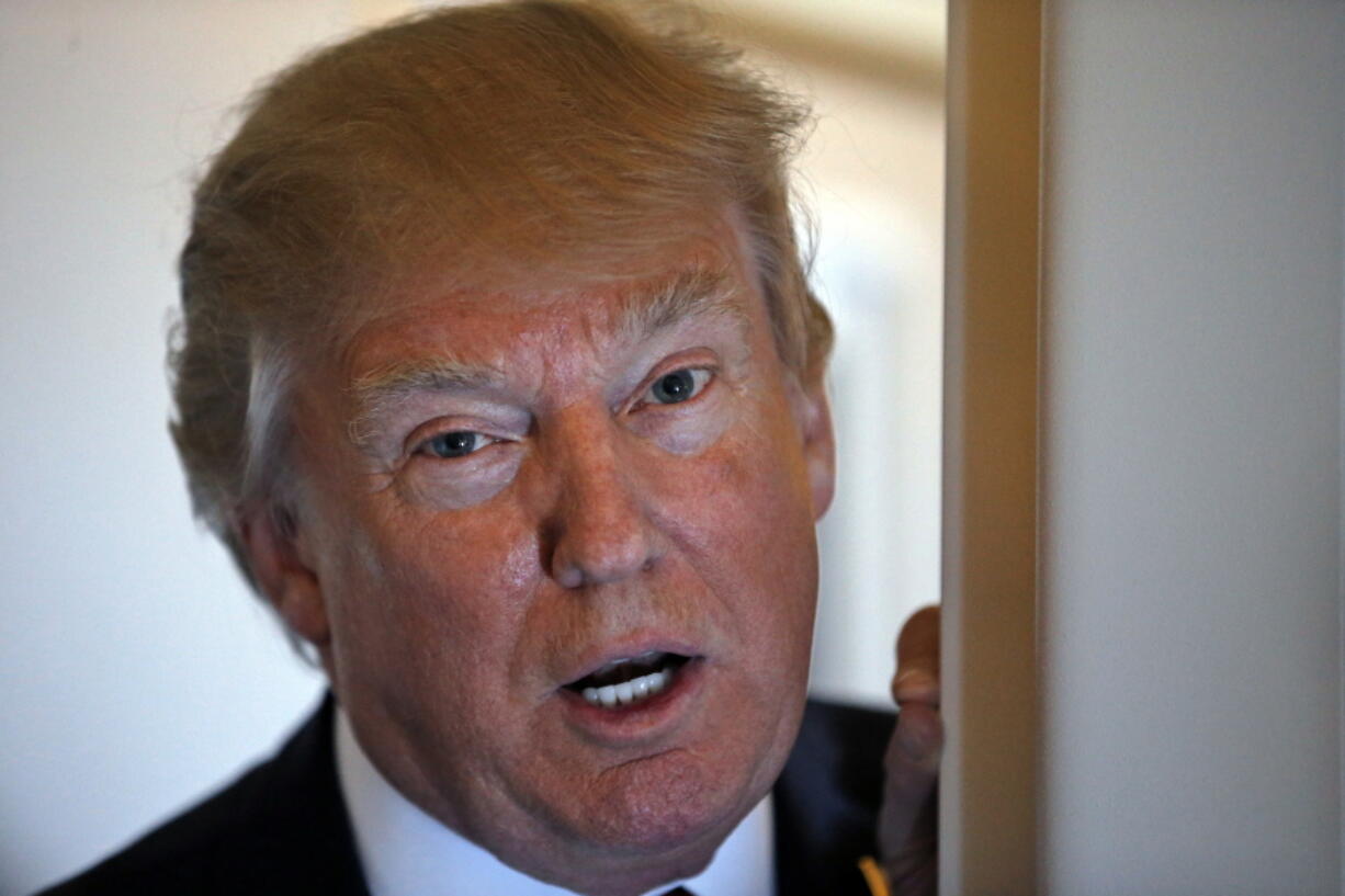 President Donald Trump speaks with reporters on Air Force One while in flight from Andrews Air Force Base, Md., to Palm Beach International Airport, Fla.