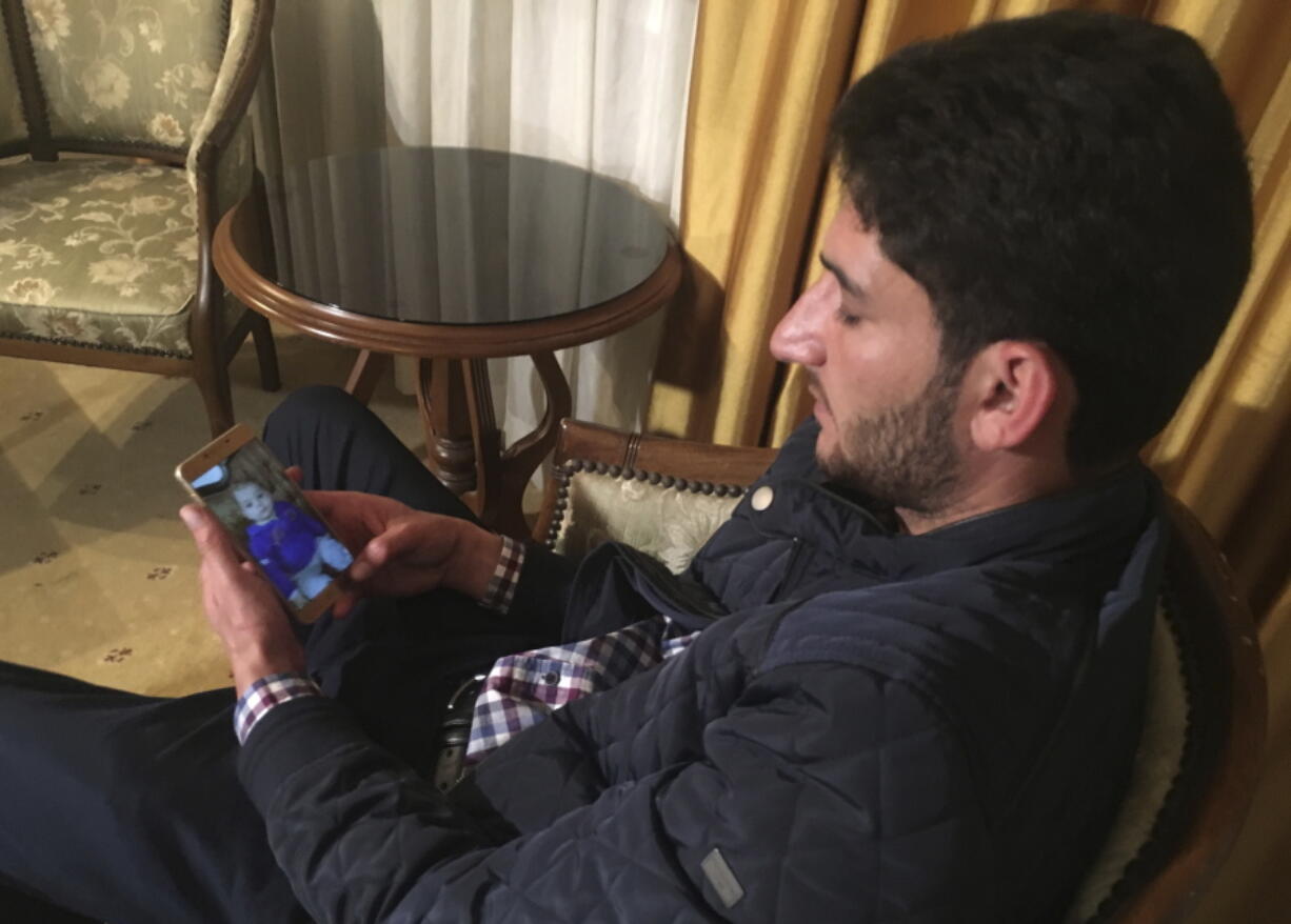 Abdel Hameed al-Yousef, 29, of Khan Sheikhoun, Syria, looks at photos of his children on his cellphone Friday in Antakya, Turkey.  His wife and 9-month-old twins were killed in Tuesday&#039;s chemical weapon attack.