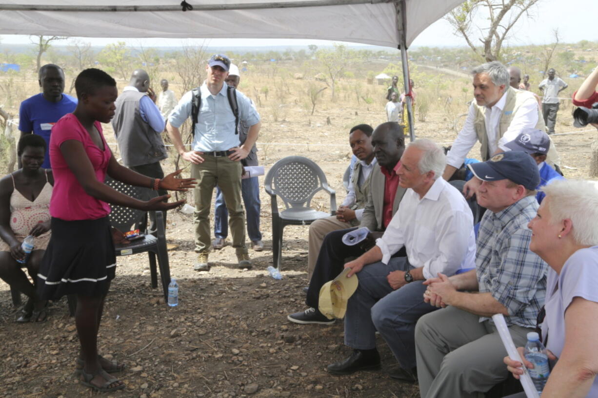 U.S. Senators Bob Corker, R-Tenn., third from right, and Chris Coons, D-Del., second from right, listen to a South Sudanese refugee Friday at the Bidi Bidi refugee settlement in northern Uganda.