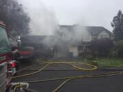 Firefighters remain at the scene of a blaze that heavily damaged a garage in Clark County's Pleasant Highlands neighborhood Monday morning.