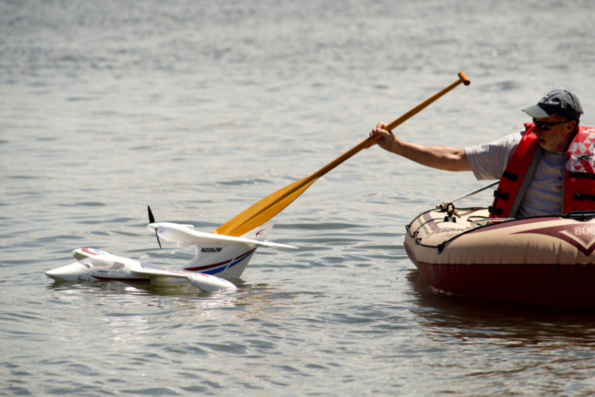 Dean Swift, a 20-year member of the Clark County Radio Control Society, fishes club member Jeff McIlvenna&#039;s waterlogged plane from Vancouver Lake Sunday afternoon. The club had its 8th annual float plane flying event Sunday at the lake.