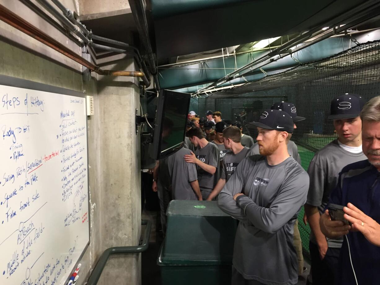 Skyview baseball team members look at hitting tips used by the Seattle Mariners in the batting cages below Safeco Field (Micah Rice/The Columbian)