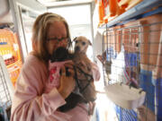 Phyllis Van Boxtel says goodbye to two dogs being taken by bus with over 100 others from crowded shelters in California to pet rescuers in the Pacific Northwest, where euthanasia rates are lower and pets are in greater demand. (Patrick T.