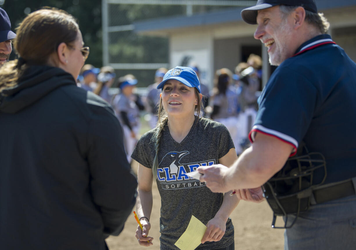 Head coach Meghan Crouse, center, talks with Mt. Hood Saints coach Brittany Hendrickson, left, and umpire Chuck Perine before their game at Clark College softball field Friday afternoon, March 31, 2017.