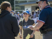 Head coach Meghan Crouse, center, talks with Mt. Hood Saints coach Brittany Hendrickson, left, and umpire Chuck Perine before their game at Clark College softball field Friday afternoon, March 31, 2017.