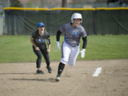 Clark freshman Karley Yoshioka, rounding the bases past head coach Meghan Crouse, went 5 for 7 with three RBI and four runs scored on the first day of the NWAC Softball Championships in Spokane on Friday, May 19, 2017.