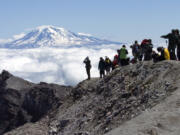 Members of the media stand at the summit of Mount St. Helens after a five-hour climb in 2006. The majority of climbing permits for the rest of this year are already sold out. Those who still want to climb the mountain will have to look for secondhand tickets or wait until October.