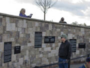 Veteran William Knight, in green hat, looks over the Battle Ground Veterans Memorial before its dedication in 2015 at Kiwanis Park in Battle Ground. On Monday, it will be the site of the city’s Memorial Day observance.