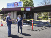 Vancouver resident Kevin Stanfield, left, talks to the manager of Laundry Love, Jackie James, about the damage caused by a Dodge Charger crashing into the front of the building. James heard about the incident soon after it happened.